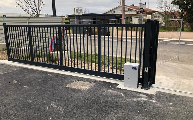 Portail coulissant automatique installé sur un site professionnel avec motorisation intégrée pour sécuriser l’accès