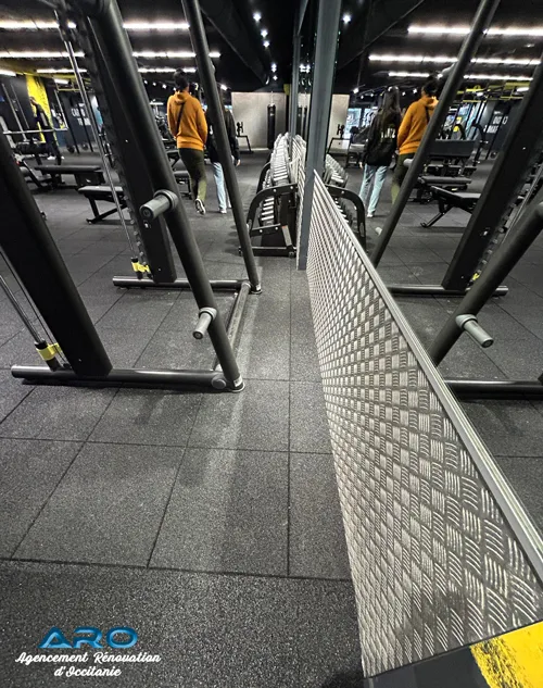 Travaux de rénovation d’une salle de sport à Toulouse par ARO avec pose de sols techniques et miroirs muraux