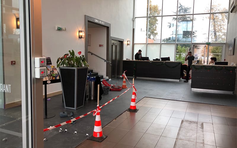 Hall d’accueil en cours de rénovation avec cônes de sécurité, rubalise et zone d’intervention balisée à Toulouse