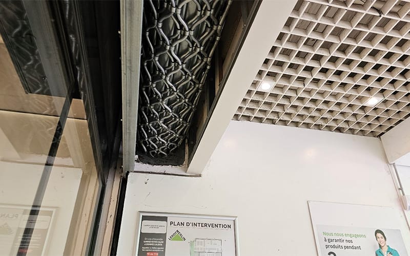 Vue en contre-plongée sur un rideau métallique intégré au plafond d’un magasin Leroy Merlin à Toulouse, en cours de réparation