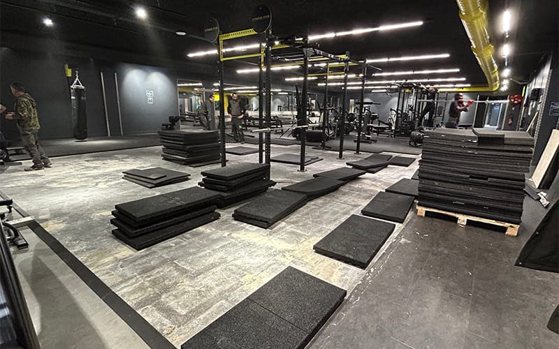 Travaux de rénovation dans une salle de sport à Toulouse avec pose de dalles en caoutchouc et installation d’équipements de musculation